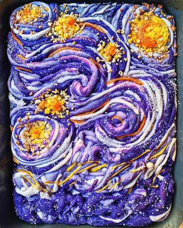Focaccia loaf made with swirls of purple dough and yellow chopped peppers