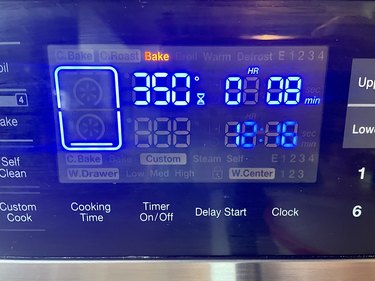 Electronic oven displaying 350 degrees on black background with blue numbers