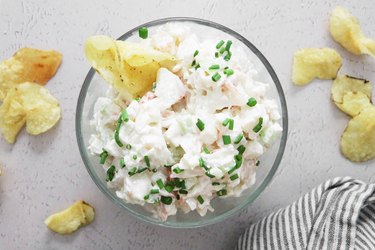 Maine lobster dip in a bowl with chives and potato chips