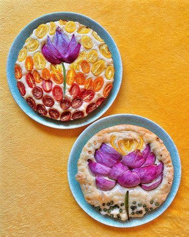 Two circular focaccia loaves featuring lotus designs made from tomatoes and onions