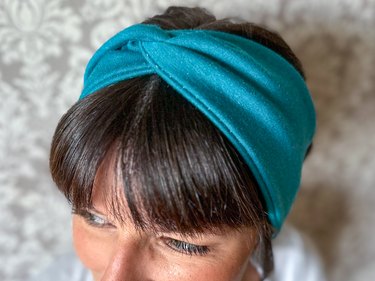 Finished stretchy twisted headband on a beautiful dark-haired woman with bangs