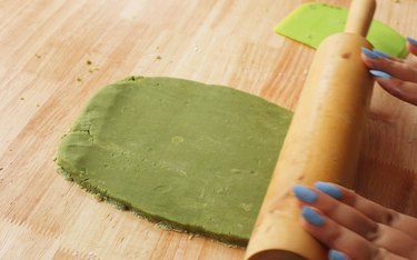 Rolling out matcha cookie dough with a rolling pin