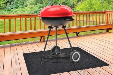 Keds grill mat, pictured under charcoal kettle on wooden deck