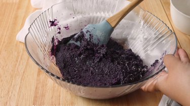 Ube cookie dough batter in a glass mixing bowl.
