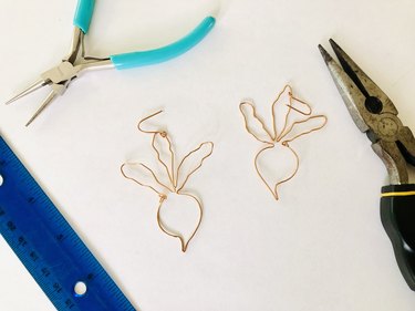 An image of two finished beet earrings, pliers, and a ruler