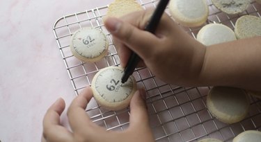 Using edible markers to draw macaron details