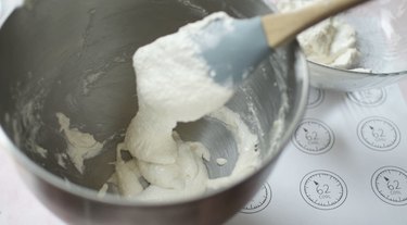 Finished white macaron batter flowing off rubber spatula