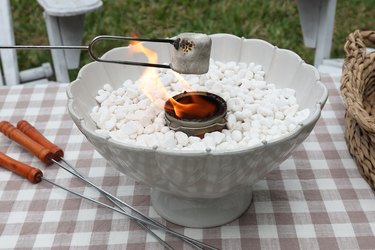 Roasting a marshmallow over a tabletop fire pit