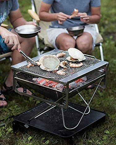 Two People Using the Snow Peak Takibi Fire & Grill to Cook Seafood