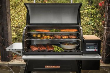 pellet grill with three racks and barbecue food on each rack