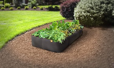Victory 8 polypropylene garden bed, shown in a well-tended landscape on a bed of mulch