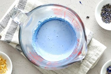 Light blue soap in a glass measuring cup
