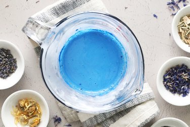 Melted soap with blue dye in a glass measuring cup
