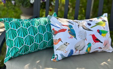 Two outdoor pillows in green art deco print and birds print