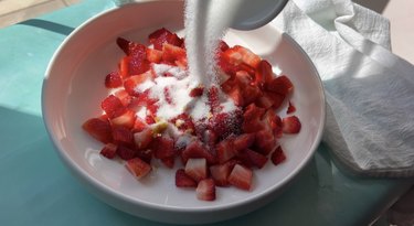 Bowl with strawberries, sugar, lemon juice and zest