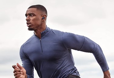 Fit Black male exercising outdoors wearing Jabra Elite 7 Bluetooth earbuds.