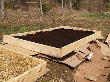 A framed-in garden bed filled with fresh soil.