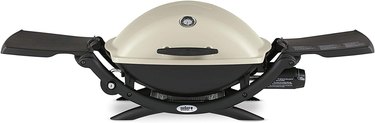 Weber Q2200 portable grill, with side tables extended, on a white ground