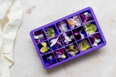 edible flowers in ice cube tray with water