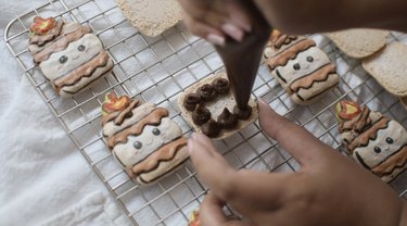 Piping chocolate ganache on macaron shell