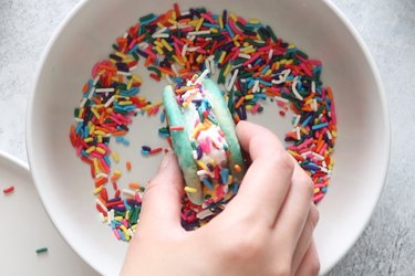 Dipping ice cream sandwich in sprinkles