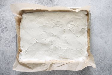 Vanilla ice cream spread on cookie sheet