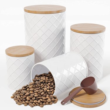 4 coffee canisters made of diamond-patterned white metal and bamboo lids. They are all different sizes and come with a plastic scoop for coffee.