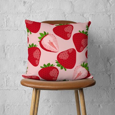 Pink square pillow with large red and pink strawberry pattern