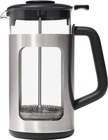 An OXO Brew GroundsLifter French Press against a white background. It has a glass and stainless steel body and a large black handle.