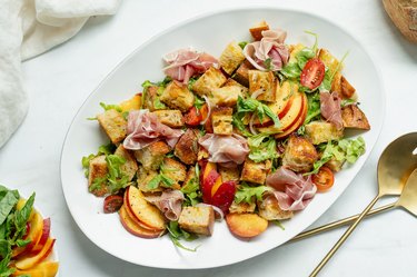 peach panzanella salad plated with serving cutlery