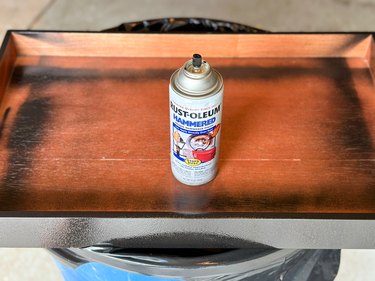 Spray paint can set atop a wood tray