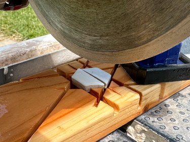 Tile saw cutting white hexagonal tile in half