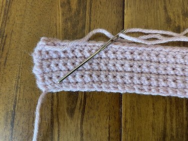 A yarn needle and pink yarn