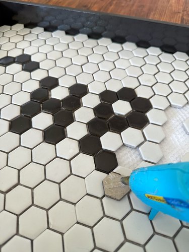 White tiles on tray with black tiles placed into empty holes