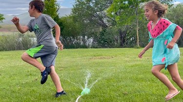 kids running through soda bottle sprinkler