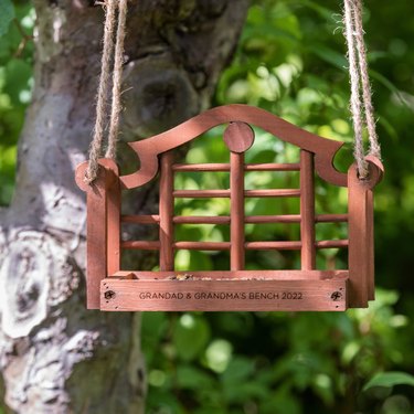 Wooden bird feeder shaped like a bench, engraved with "Grandad & Grandma's Bench 2022"