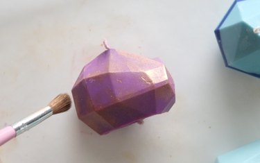 Brushing gold mica powder on a gemstone candle