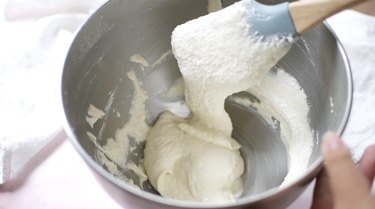 Macaron batter flowing off rubber spatula