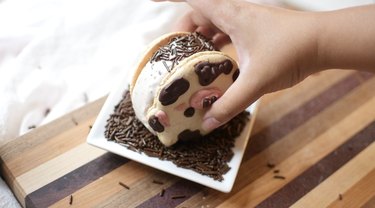 Rolling ice cream macarons into chocolate sprinkles