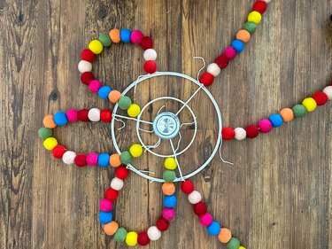 attach other end of pom pom strings to embroidery hoop