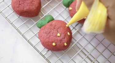 Decorating strawberry cookies with melted chocolate