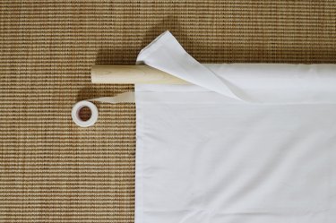 Hem tape placed under fabric folded over dowel