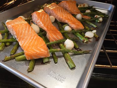 Salmon dinner with asparagus and pearl onions on a Chicago Metallic sheet pan