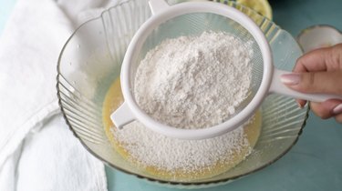 Sifting flour and salt into batter.