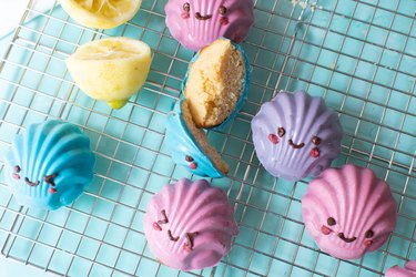 Madeleine cookies shaped like seashells with light pink, purple and blue coating