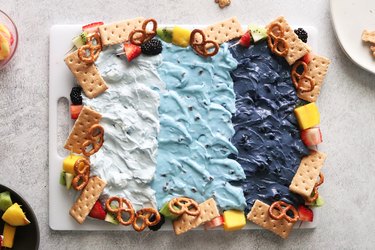 Dessert dip board with fruit, pretzels and graham crackers