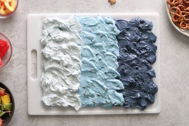 Three dips on a cutting board, styled to look like blue ocean waves