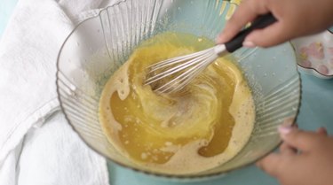 Whisking melted butter into the mixture.