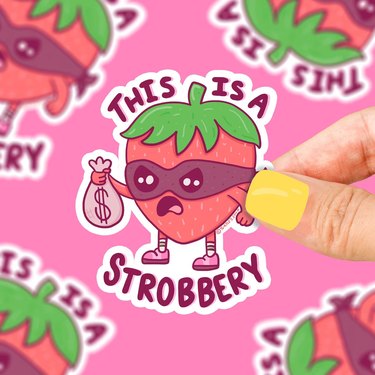 Sticker showing masked strawberry captioned "THIS IS A STROBBERY"