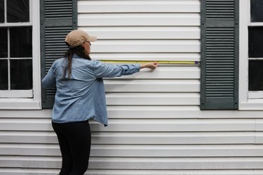 Measuring outdoor wall space with a tape measure